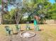 Outdoor fire pit area featuring seating and play set, offering a relaxing space for outdoor activities at 39 Lake Dr, Debary, FL 32713