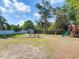 Spacious backyard showcasing a fire pit area with chairs and a play set on a sunny day at 39 Lake Dr, Debary, FL 32713