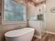 Modern bathroom featuring a soaking tub, glass-enclosed shower, and stylish lighting fixtures and finishes at 39 Lake Dr, Debary, FL 32713