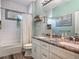 Bathroom with a double sink vanity, granite counters, subway tiled walls, bathtub, and walk-in shower at 39 Lake Dr, Debary, FL 32713