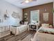 Comfortable bedroom featuring twin beds, decorative wall art, natural light, and wood-look floors at 39 Lake Dr, Debary, FL 32713