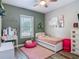 Cozy bedroom with pink accents, a charming vanity, wood-look floors, and natural light at 39 Lake Dr, Debary, FL 32713
