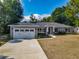 Charming home featuring a two-car garage, manicured lawn, and inviting front entrance on a sunny day at 39 Lake Dr, Debary, FL 32713