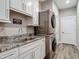 A functional laundry room is equipped with modern washer/dryer units, granite countertops, and ample cabinet space at 39 Lake Dr, Debary, FL 32713