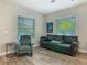 Cozy living room featuring a comfortable sofa, armchair, and two bright windows at 39 Lake Dr, Debary, FL 32713