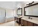 Bright bathroom featuring double vanities, a soaking tub, and a separate glass-enclosed shower at 3904 Woodsfield Ct, Orlando, FL 32822