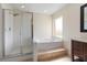 Bright bathroom featuring a soaking tub, glass-enclosed shower, and neutral tiling at 3904 Woodsfield Ct, Orlando, FL 32822