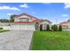 Beautiful two-story home with a red tile roof, three-car garage, and manicured lawn at 3904 Woodsfield Ct, Orlando, FL 32822