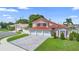 Two-story home features red tile roof, three-car garage, and well-manicured lawn at 3904 Woodsfield Ct, Orlando, FL 32822