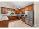 Modern kitchen with stainless steel appliances, wood cabinets, and tile flooring at 3904 Woodsfield Ct, Orlando, FL 32822