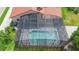 Aerial view of a screened-in pool with clear blue water and an exterior view of the home at 3904 Woodsfield Ct, Orlando, FL 32822