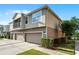 A townhome featuring a two-car garage and a side yard with lush landscaping at 3917 Pemberly Pines Cir, St Cloud, FL 34769