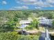 Aerial view of a waterfront property with a pool, a dock, and a boat lift amid lush greenery at 3960 Lake Mira Dr Dr, Orlando, FL 32817