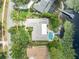 Aerial view showcases a stunning backyard pool, complemented by lush landscaping and lake access at 3960 Lake Mira Dr Dr, Orlando, FL 32817