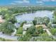 Stunning aerial view of lakefront property surrounded by lush greenery and beautiful blue skies at 3960 Lake Mira Dr Dr, Orlando, FL 32817