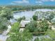 Overhead view of lakefront home surrounded by mature trees, featuring a well-manicured lawn at 3960 Lake Mira Dr Dr, Orlando, FL 32817