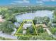 Breathtaking lakefront property surrounded by lush greenery and highlighted in yellow, showcasing its boundaries at 3960 Lake Mira Dr Dr, Orlando, FL 32817