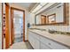 Bright bathroom featuring a large mirror, vanity, and walk-in shower area behind an open, wood-framed doorway at 3960 Lake Mira Dr Dr, Orlando, FL 32817