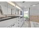 Well-lit bathroom featuring double sinks, a stylish vanity, and a pristine white bathtub at 3960 Lake Mira Dr Dr, Orlando, FL 32817