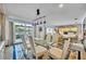Elegant dining room with water views, glass table, white chairs, and a modern blue pendant light fixture at 3960 Lake Mira Dr Dr, Orlando, FL 32817