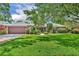 Charming single-story home featuring a manicured lawn, mature trees, and a stone-accented facade, with a two-car garage at 3960 Lake Mira Dr Dr, Orlando, FL 32817