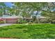 Charming single-story home featuring a manicured lawn, mature trees, and a stone-accented facade, with a two-car garage at 3960 Lake Mira Dr Dr, Orlando, FL 32817