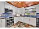Modern kitchen featuring white cabinets, stainless steel appliances, stylish backsplash, and unique flooring at 3960 Lake Mira Dr Dr, Orlando, FL 32817