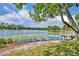 Picturesque view from the shore, showcasing a serene lake with a dock and a bench at 3960 Lake Mira Dr Dr, Orlando, FL 32817