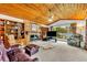 Cozy living room with a stone fireplace, wood ceiling, built-in shelving, and scenic water views at 3960 Lake Mira Dr Dr, Orlando, FL 32817