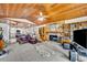 Inviting living room featuring a stone fireplace, wood ceiling, built-in shelving, and open access to the kitchen at 3960 Lake Mira Dr Dr, Orlando, FL 32817