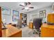 Home office with two wood desks, wood bookshelf, ceiling fan, and natural light from a window at 3960 Lake Mira Dr Dr, Orlando, FL 32817