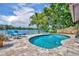 Inviting backyard pool area with comfortable lounge chairs, set against a backdrop of serene lake views and lush greenery at 3960 Lake Mira Dr Dr, Orlando, FL 32817