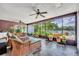 Inviting sunroom featuring tiled floors, wicker furniture, ceiling fans and views of a serene lake at 3960 Lake Mira Dr Dr, Orlando, FL 32817