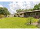Spacious backyard with lush green grass, palm trees, and an enclosed porch at 429 Kimberly Ct, Sanford, FL 32771