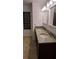 Bathroom featuring a dual vanity with granite countertop, dark cabinetry, and a glass block window at 4920 E Lake Cove Blvd, St Cloud, FL 34771