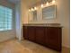 Bathroom vanity with granite counters, double sinks, and bright lighting at 4920 E Lake Cove Blvd, St Cloud, FL 34771