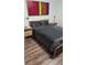 Bedroom with a wooden bed frame, gray bedding, hardwood floors, and modern art at 4920 E Lake Cove Blvd, St Cloud, FL 34771