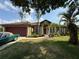 Charming single-Gathering home featuring a well-manicured lawn, mature trees, and a two-car garage at 4920 E Lake Cove Blvd, St Cloud, FL 34771