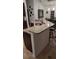 Kitchen island featuring a granite countertop, stainless steel sink, and breakfast bar seating at 4920 E Lake Cove Blvd, St Cloud, FL 34771