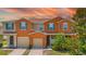 Inviting townhome with a two car garage, blue shutters, and warm orange exterior paint at 5118 Adelaide Dr, Kissimmee, FL 34746