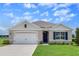 Charming single-Gathering home featuring a two-car garage, manicured lawn, and traditional architectural details at 5133 Masser Rd, St Cloud, FL 34772