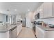 Bright kitchen features stainless steel appliances, granite countertops, and white cabinets at 5133 Masser Rd, St Cloud, FL 34772