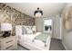 Inviting bedroom with patterned accent wall, plush bedding, and plenty of natural light at 540 Southern Edge Way, Sanford, FL 32771