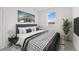 Comfortable bedroom showcasing a queen bed with stylish bedding, modern art and a bright window at 555 Southern Edge Way, Sanford, FL 32771