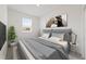 A stylish bedroom featuring a queen bed with a gray headboard, modern art, and a bright window at 555 Southern Edge Way, Sanford, FL 32771