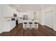Modern kitchen with white cabinets, stainless steel appliances, a center island with stools and hardwood floors at 555 Southern Edge Way, Sanford, FL 32771
