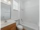 Bright bathroom with white tile, a shower-tub combo, and a wood vanity with a framed mirror at 7021 Della Dr # 51, Orlando, FL 32819