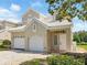 Beautiful townhome showcasing an attached garage, lovely front yard greenery, and a pristine white front door at 7021 Della Dr # 51, Orlando, FL 32819