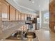 Kitchen area featuring wooden cabinets, modern appliances, a double basin sink, and tile backsplash at 7021 Della Dr # 51, Orlando, FL 32819