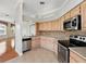 Open concept kitchen featuring stainless steel appliances, light cabinets, and easy access to living areas at 7021 Della Dr # 51, Orlando, FL 32819